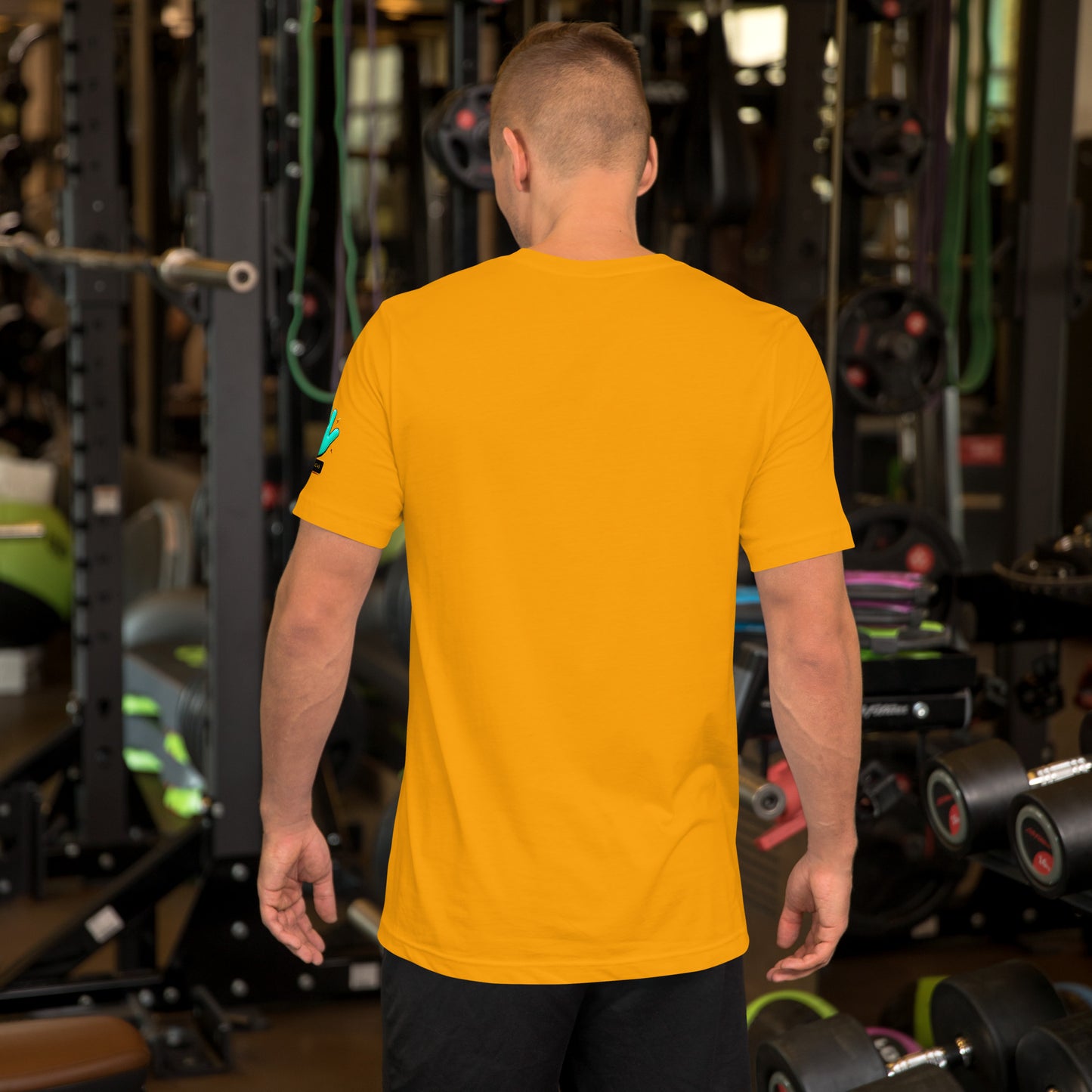 Modelo en gimnasio mostrando la vista trasera de camiseta amarilla de manga corta, marca Bofetadas, colección 'Pop', sin impresión.