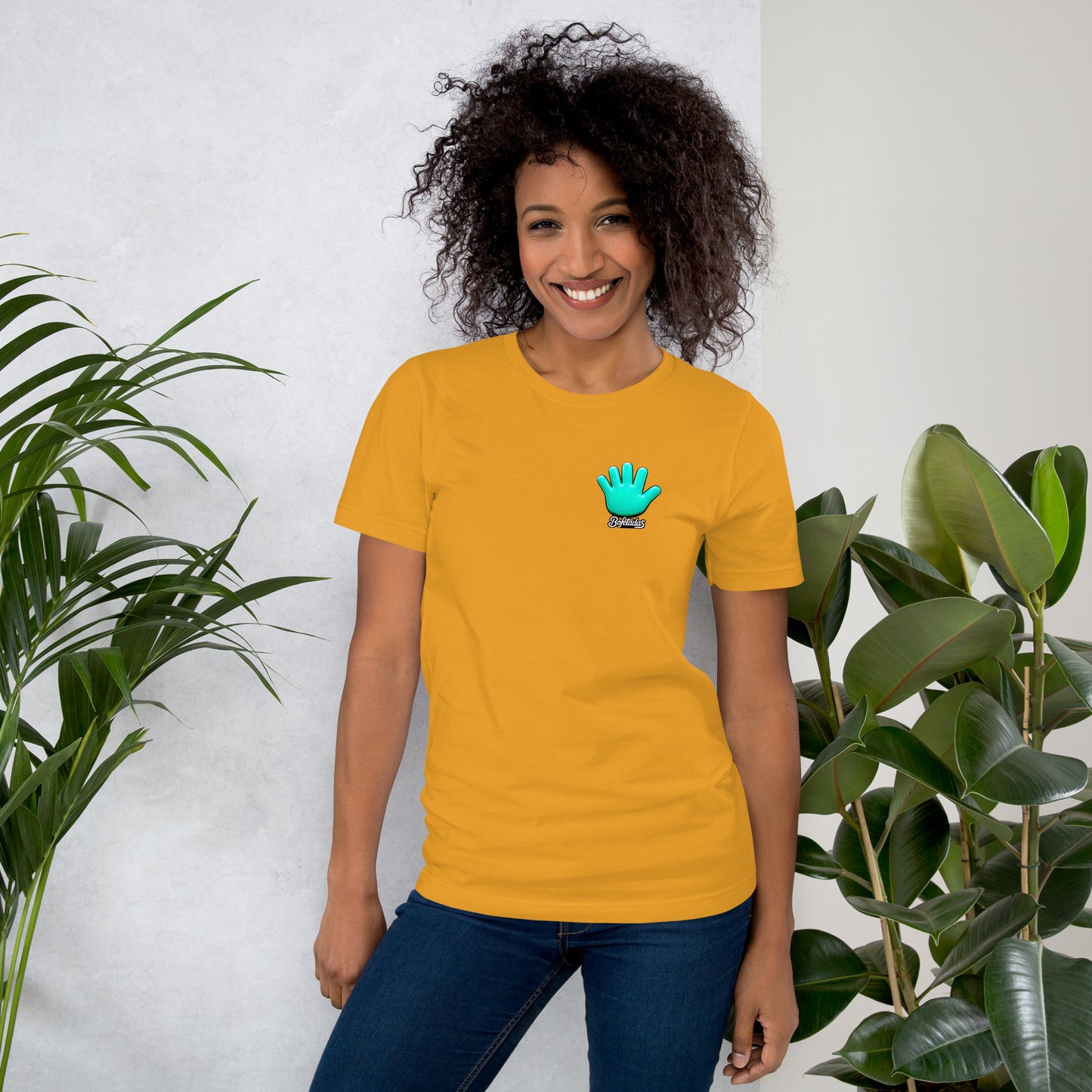 Modelo sonriente con jeans luciendo camiseta amarilla de manga corta marca Bofetadas, colección 'Animales', vista delantera, con logo de mano azul en el corazón.