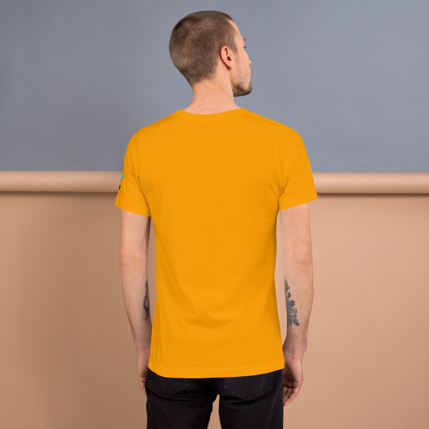 Modelo tatuado mostrando la vista trasera de camiseta amarilla de manga corta, marca Bofetadas, colección 'Celebrities', sin impresión.