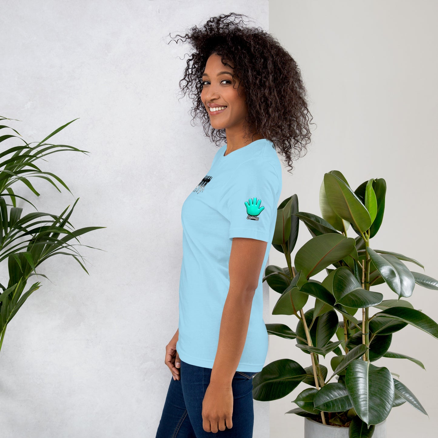 Modelo mostrando la vista lateral de camiseta azul claro de manga corta, marca Bofetadas, colección 'Causas Sociales', con el logotipo de Bofetadas de una mano azul en la manga.