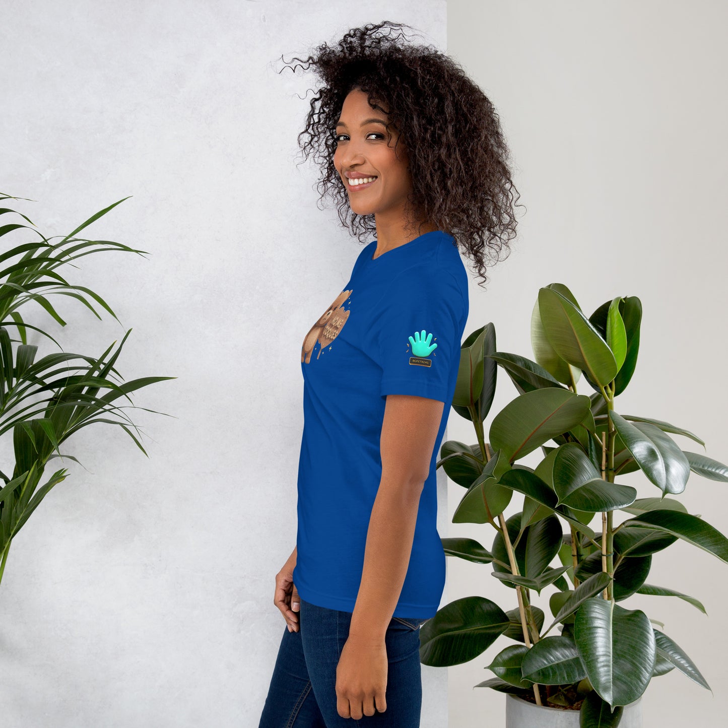 Modelo mostrando la vista lateral de camiseta azul de manga corta, marca Bofetadas, colección 'Frases y Mensajes', con el logotipo de una mano azul en la manga.