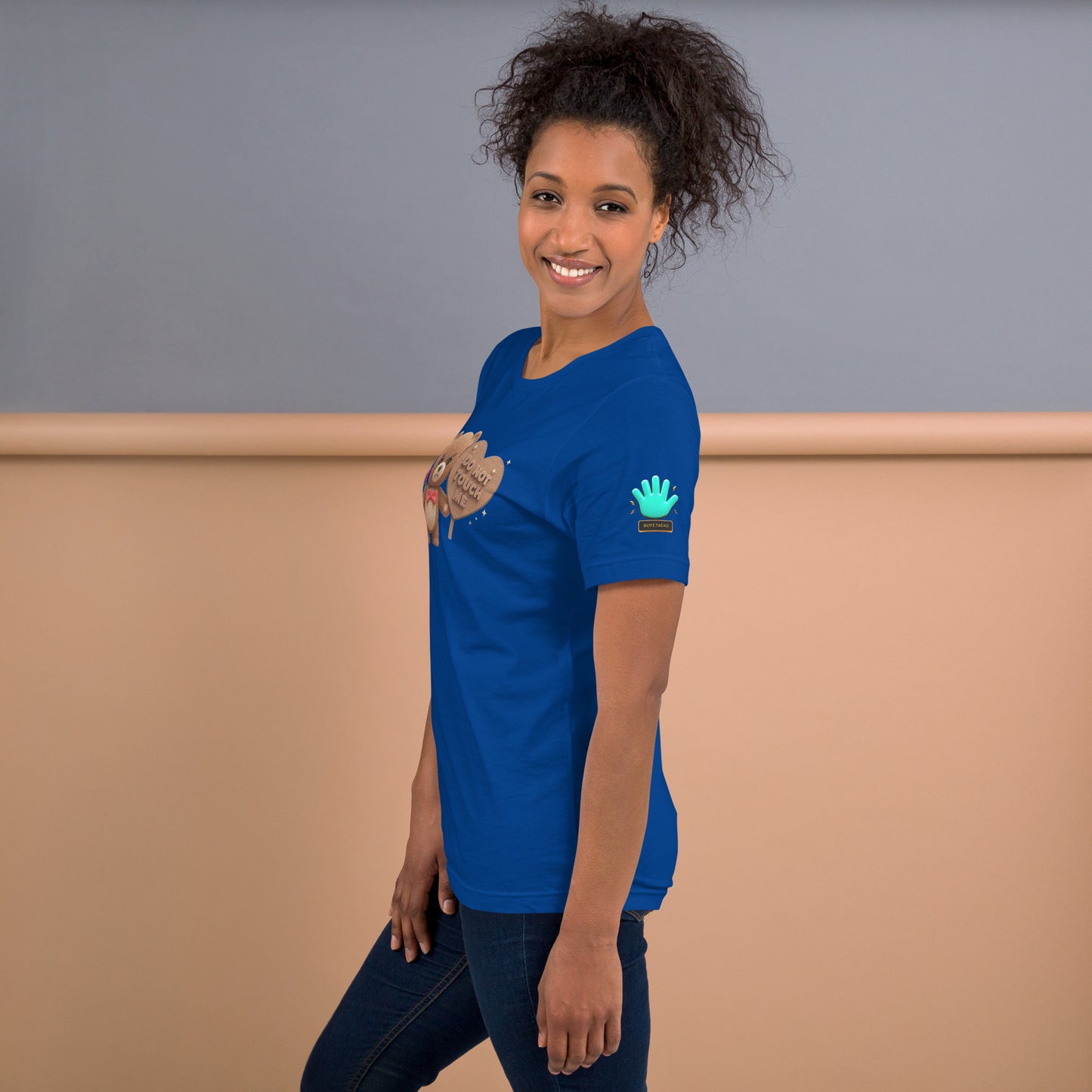 Modelo mostrando la vista lateral de camiseta azul de manga corta, marca Bofetadas, con el logotipo de una mano azul en la manga.