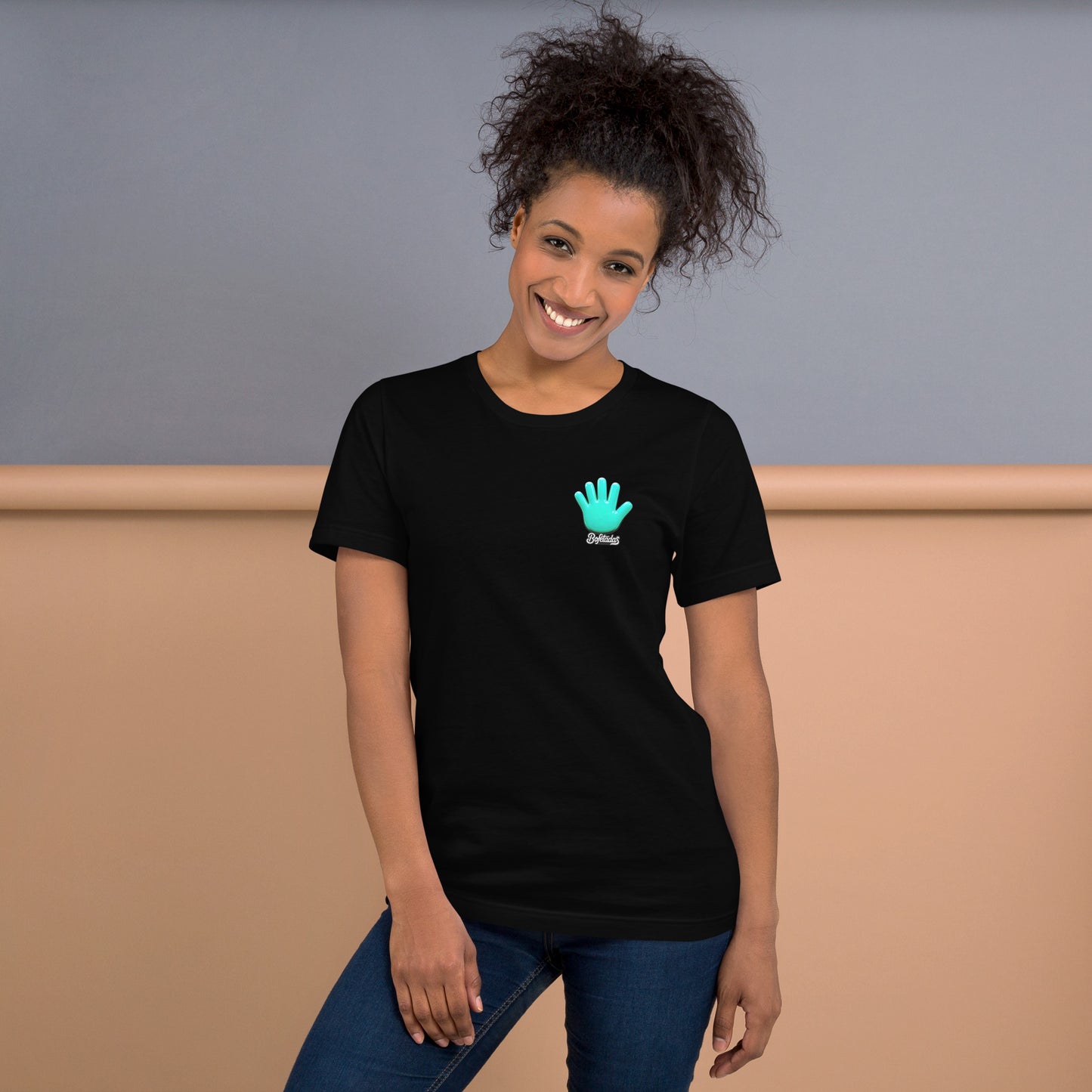 Vista frontal de la camiseta negra que luce una modelo sonriente con vaqueros de la colección Marca y serie Sports de Bofetadas. En el pecho esta impreso el logotipo de Bofetadas y el nombre Bofetadas.