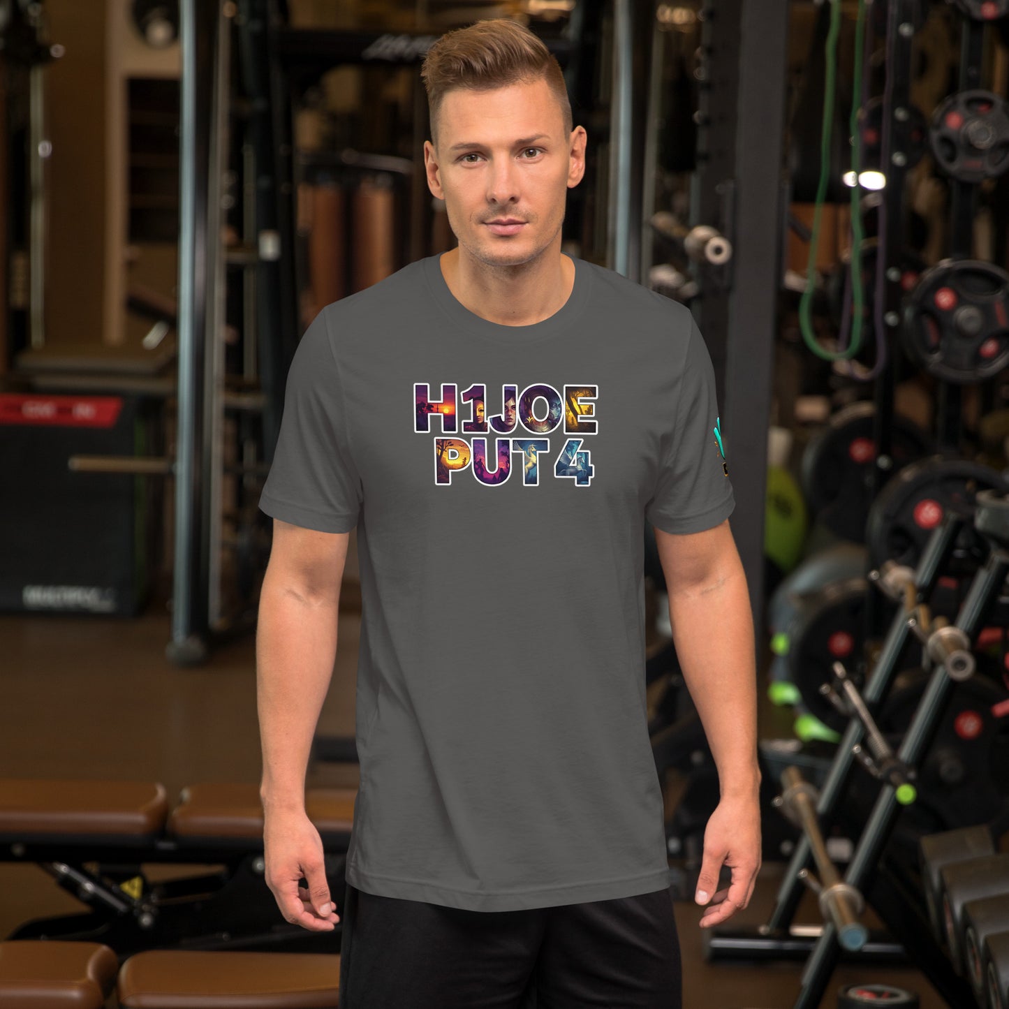 Modelo en gimnasio luciendo camiseta gris de manga corta marca Bofetadas, colección 'Irreverentes', con texto 'H1JOEPUT4' de letras artísticas con gráficos para el relleno de las mismas y borde blanco.