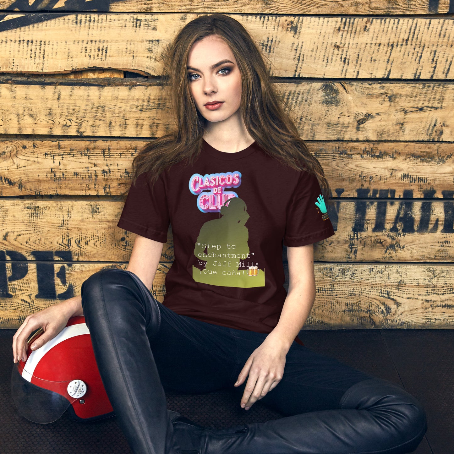 Camiseta marrón de manga corta de la colección Clásicos de Club, dedicada al tema 'Step to Enchantment' de Jeff Miles, un tema de techno Detroit. En la imagen se muestra una modelo sentada con un casco de moto, llevando la camiseta con el diseño de la colección.