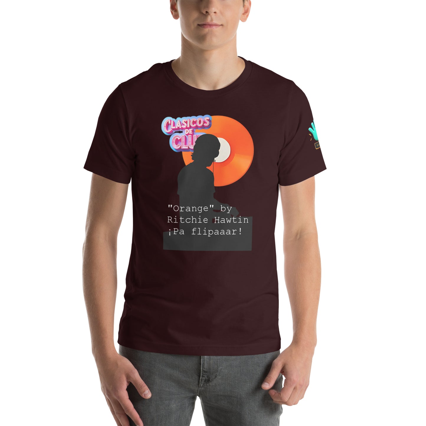 Vista frontal de camiseta marrón de la colección Clásicos de Club, con logotipo de la colección, una figura de DJ en negro y un disco naranja con el texto '¡pa flipar!'.