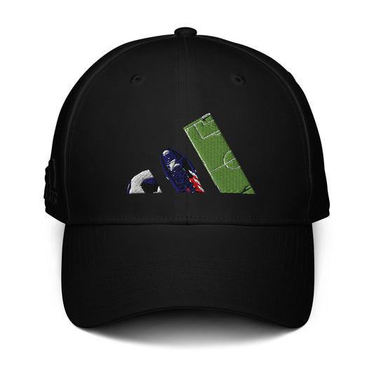 Gorra negra de la colección Adidas Bofetadas. Bordado frontal con las tres bandas del logotipo de Adidas representadas por una pelota, una bota de fútbol y un trozo de césped de campo de fútbol.