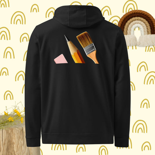 Vista trasera de la sudadera negra con capucha de la colección Adidas Bofetadas, dedicada a los pintores. En el diseño del logotipo de Adidas, las tres bandas están formadas por una goma de borrar, un lápiz y un pincel.
