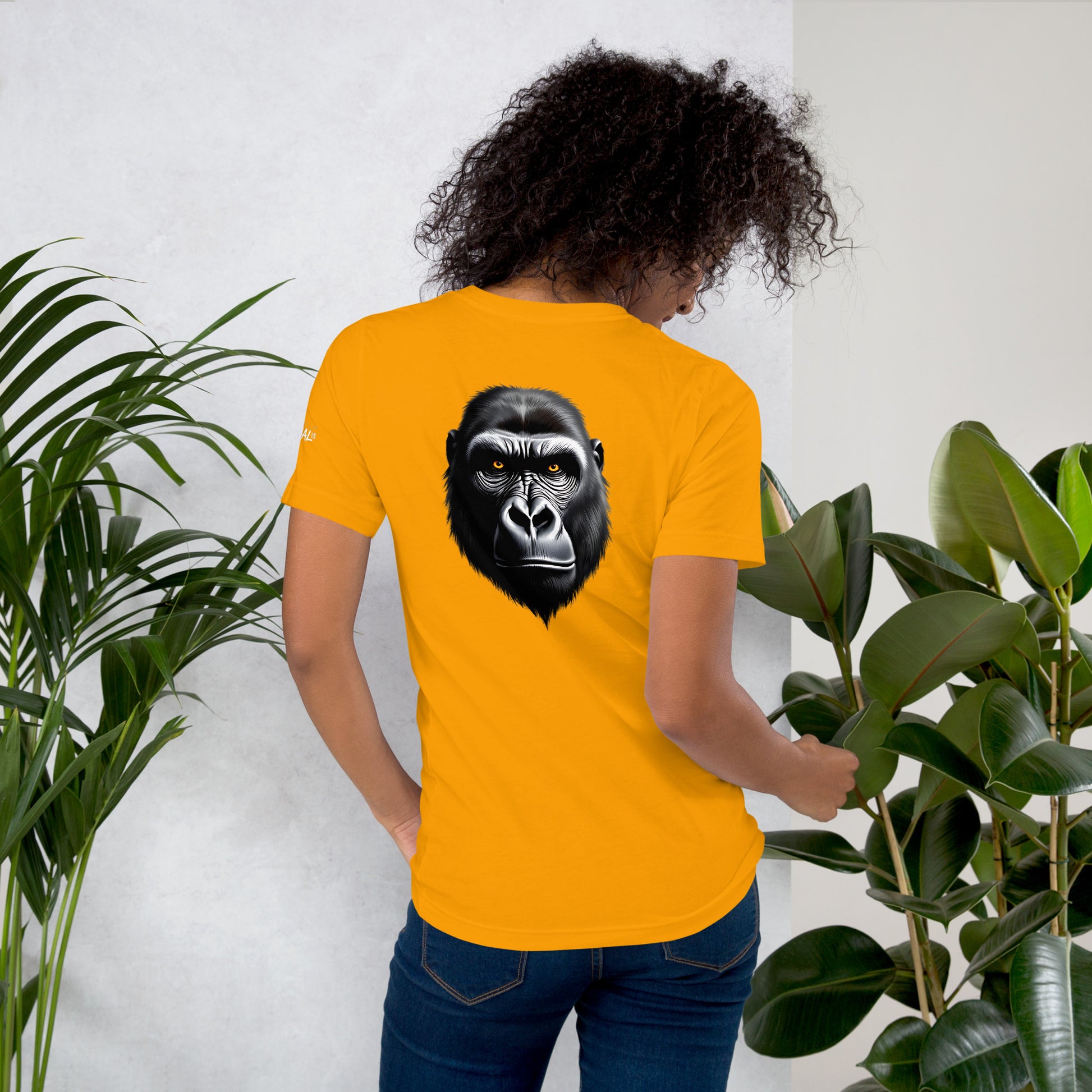 Vista trasera de la camiseta amarilla de manga corta de la colección Animales, llevada por una modelo, con una ilustración de la faz de un gorila impresa.