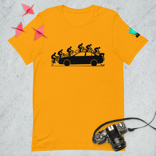 Vista frontal de una camiseta amarilla de manga corta de la colección Causas Sociales, con una ilustración en negro que muestra irónicamente a un coche siendo abordado por varias bicicletas.