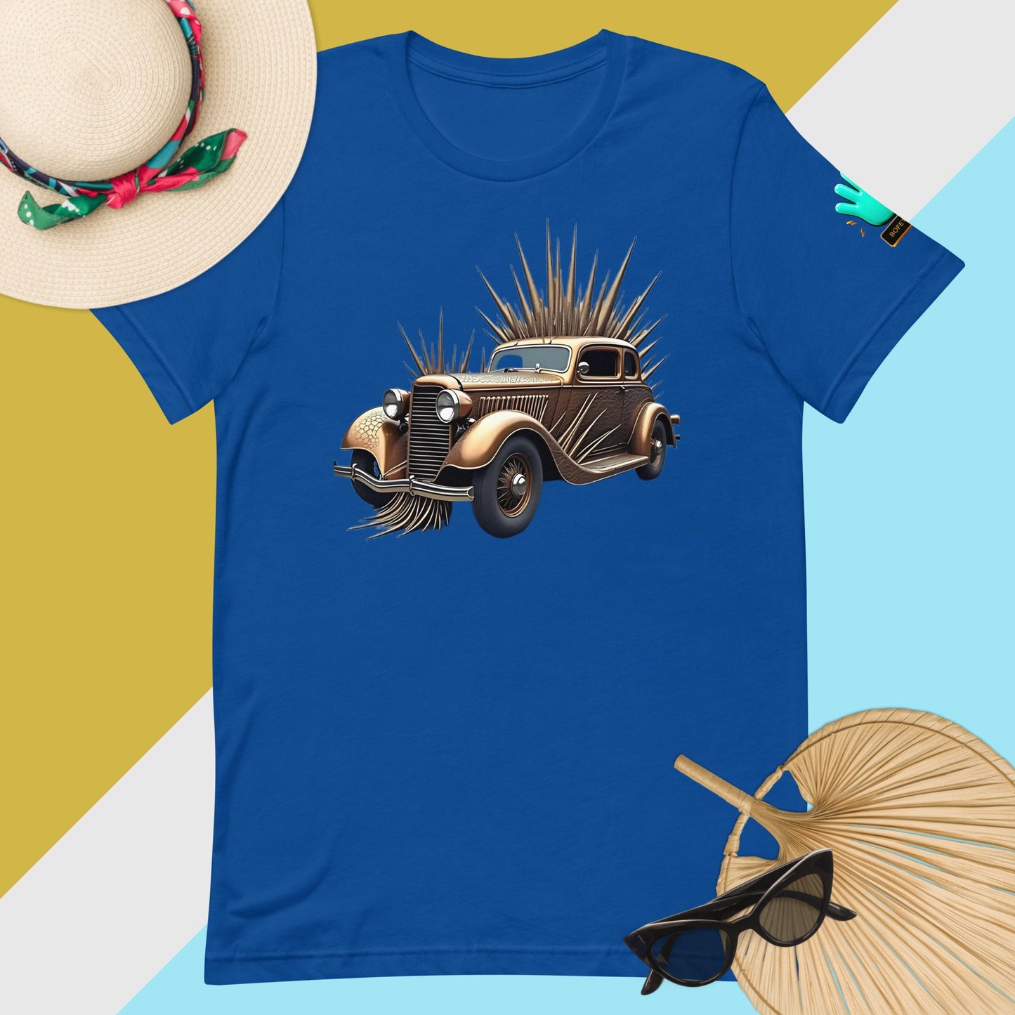 Fotografía digital de una camiseta azul de manga corta de la marca Bofetadas. En el pecho se muestra la imagen de un coche clásico americano de los años 50, en color marrón metalizado, con detalles de pinchos en el techo, capó, parachoques y lateral de una rueda. Imagen frontal del diseño.