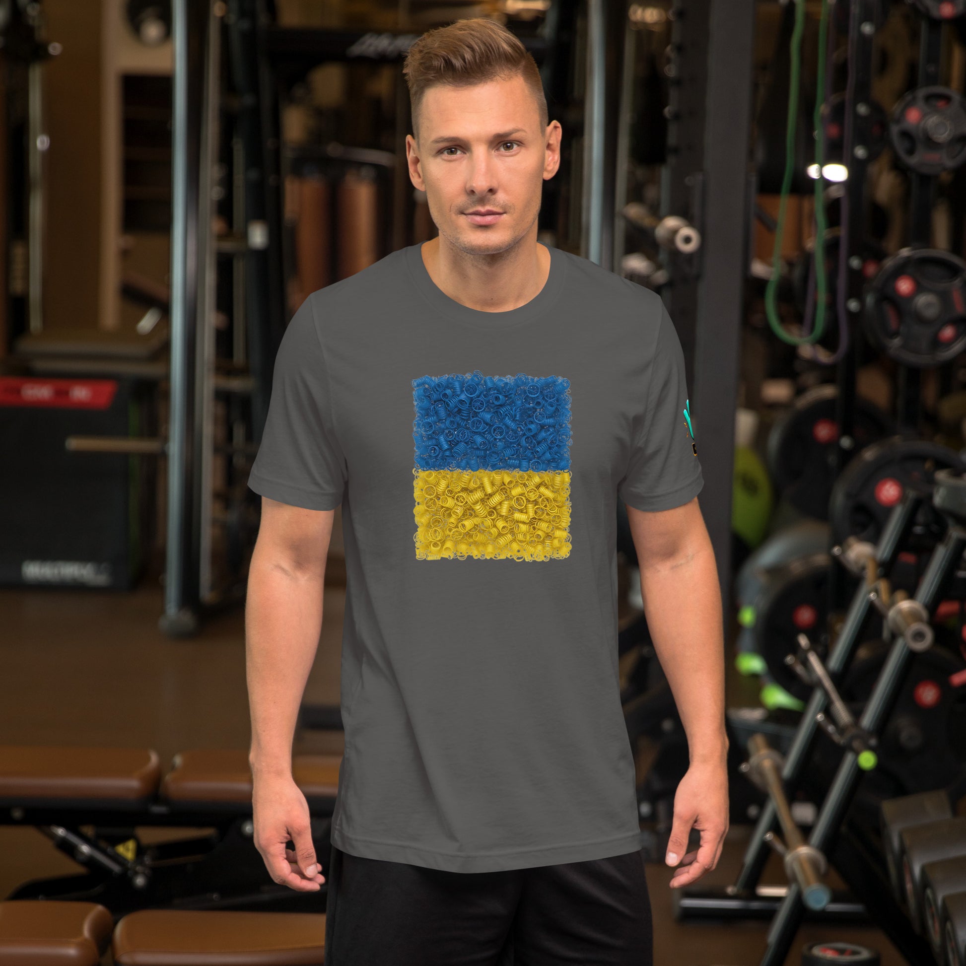 Vista frontal de una camiseta gris de manga corta de la colección Causas Sociales, con una impresión de la bandera de Ucrania formada por muelles que simbolizan la resistencia. La camiseta la lleva un modelo.