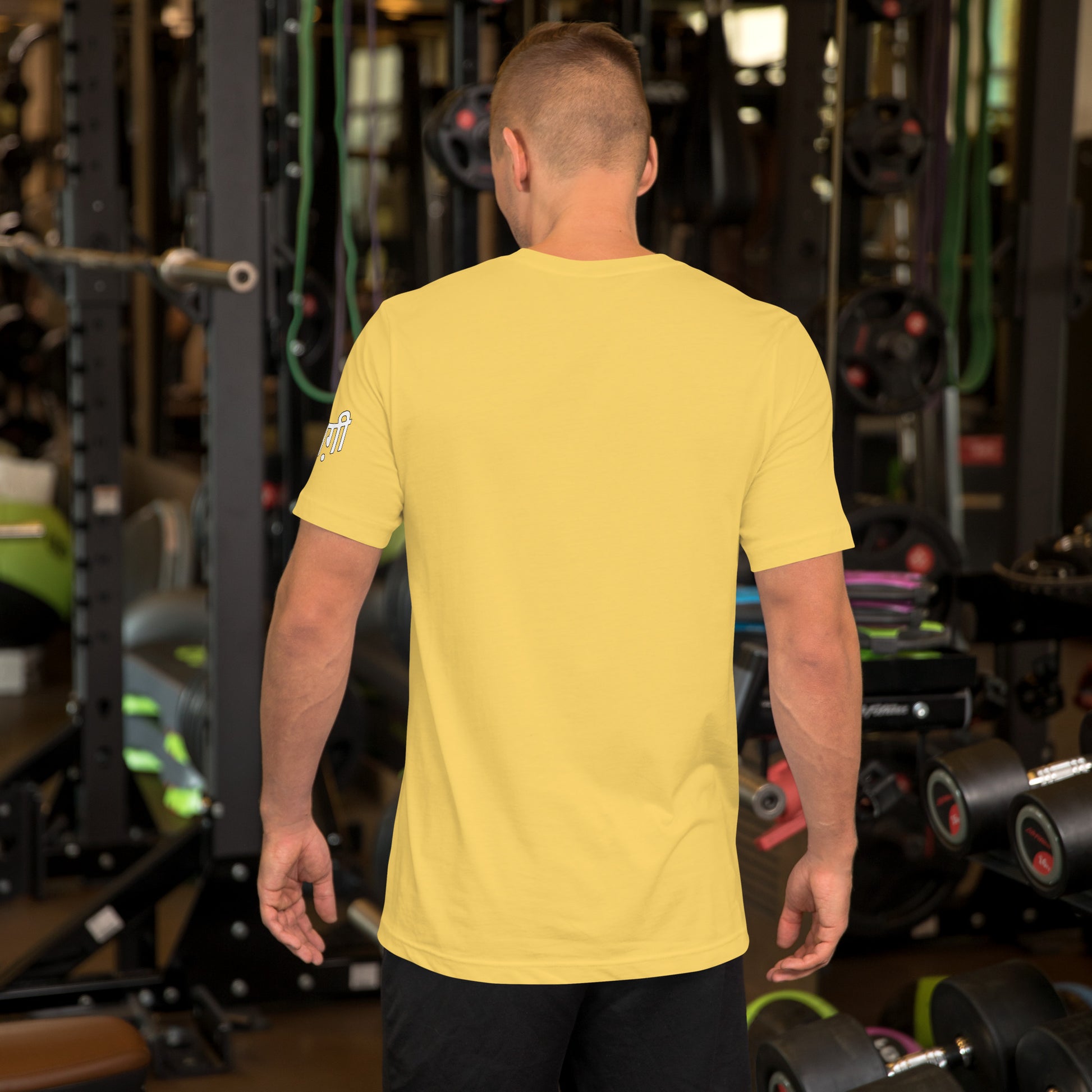 Camiseta color amarilla de la colección 'Marca' sin impresión. La luce un modelo en el gimnasio.