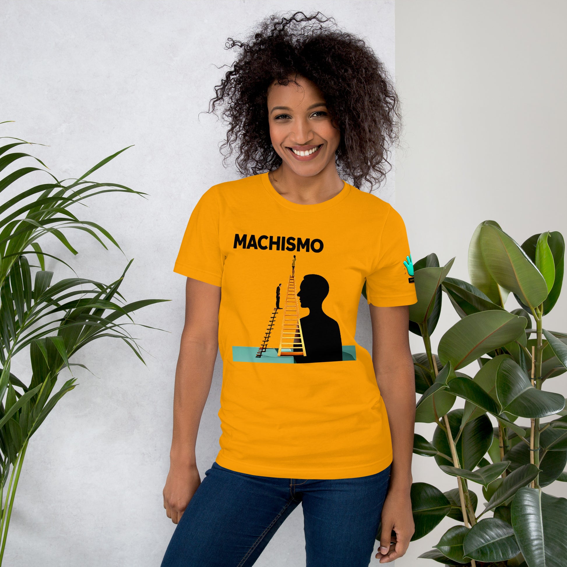 Camiseta amarilla de manga corta marca Bofetadas, colección Causas Sociales sobre machismo, con imagen de mujer en escalera y siluetas de hombres observando.