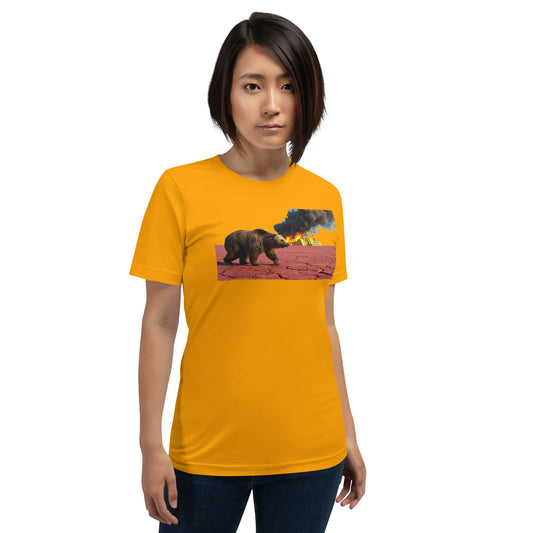 Modelo luciendo camiseta amarilla de manga corta marca Bofetadas, colección 'Causas Sociales', con fábrica humeante y oso en tierra reseca ne referencia al cambio climático.