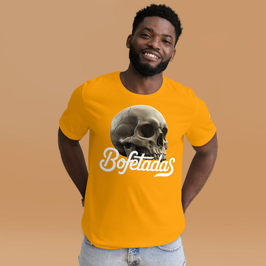 Un modelo luce en un  estudio la camiseta amarilla de manga corta marca Bofetadas, colección 'Calaveras', con una calavera sin mandíbula inferior en la impresión encima del texto "Bofetadas".