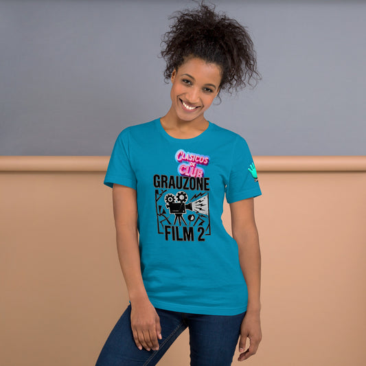 Una modelo sonriente y con jeans muestra la vista frontal de una camiseta de Bofetadas azul con la impresión del logo de la colección Clásicos de Club y una lustración de una cámara de grabación de cine y el texto Grauzone film 2 en negro con un borde blanco fino. 