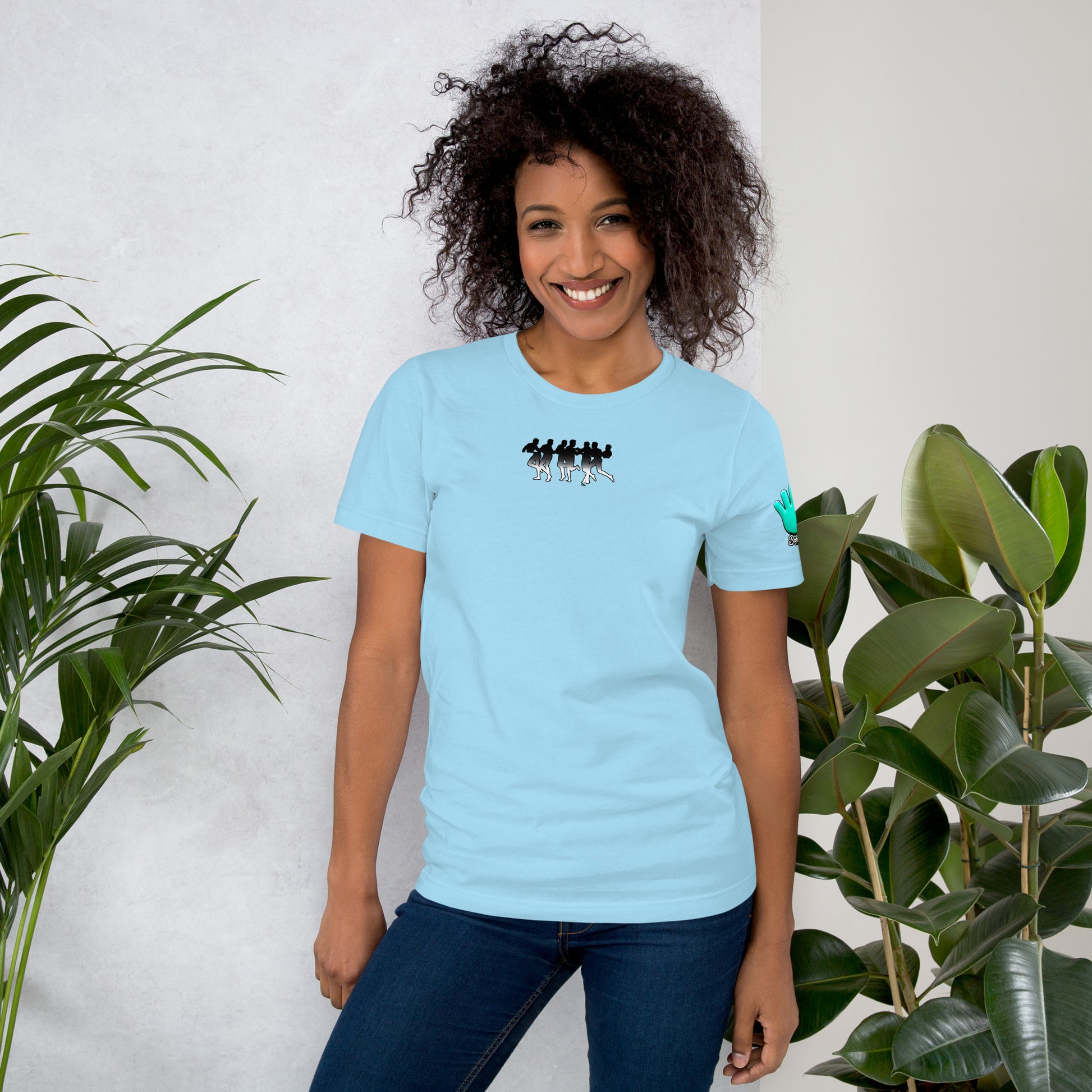Una modelo sonriente con jeans luce una camiseta azul claro de manga corta marca Bofetadas, colección 'Causas Sociales', con impresión extravagante de mitades de cuerpos de chicos con barba y chicas, unidas. Imagen en blanco y negro degradados.
