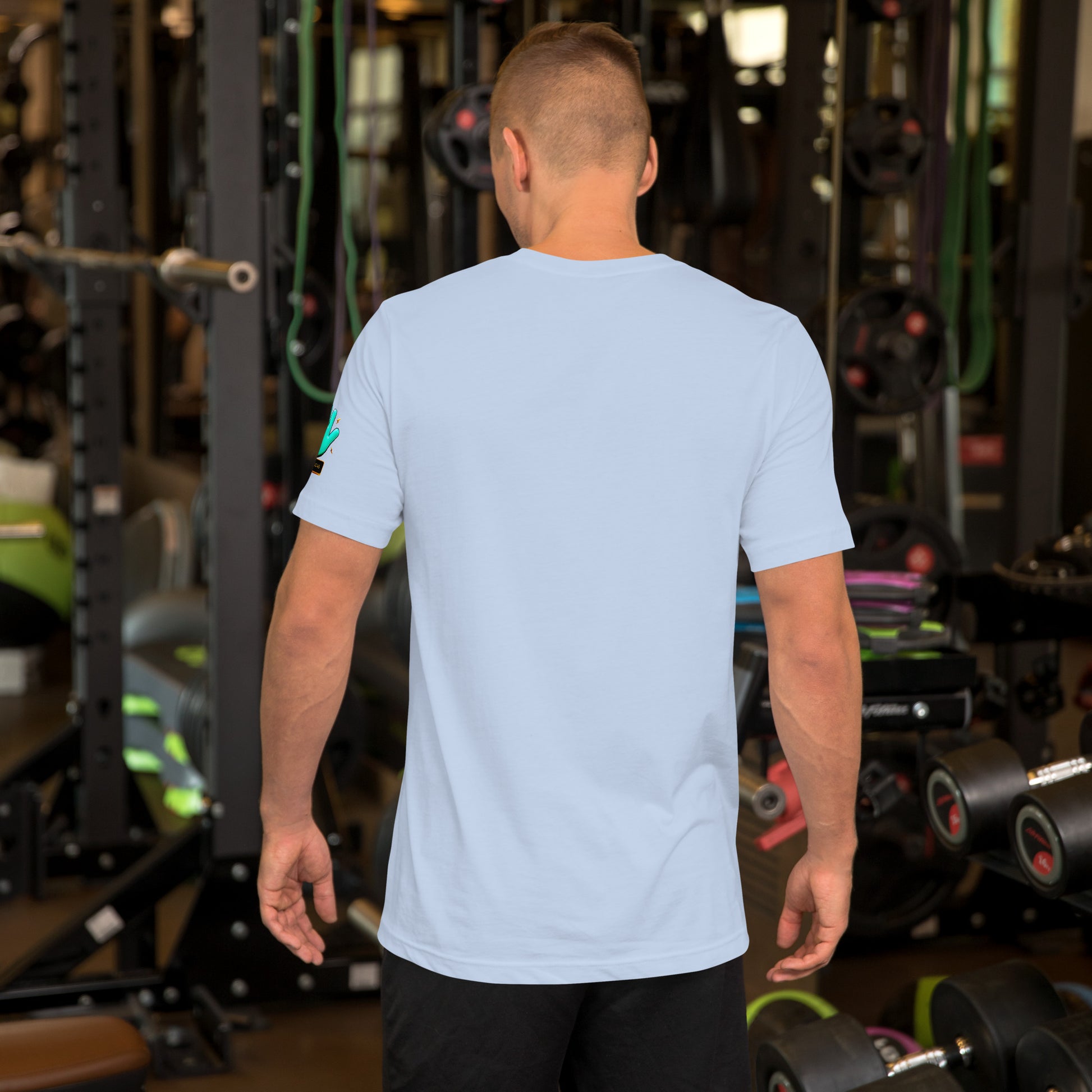 Modelo en gimnasio mostrando la vista trasera de camiseta azul claro de manga corta, marca Bofetadas, colección 'Frases y Mensajes', sin impresión.