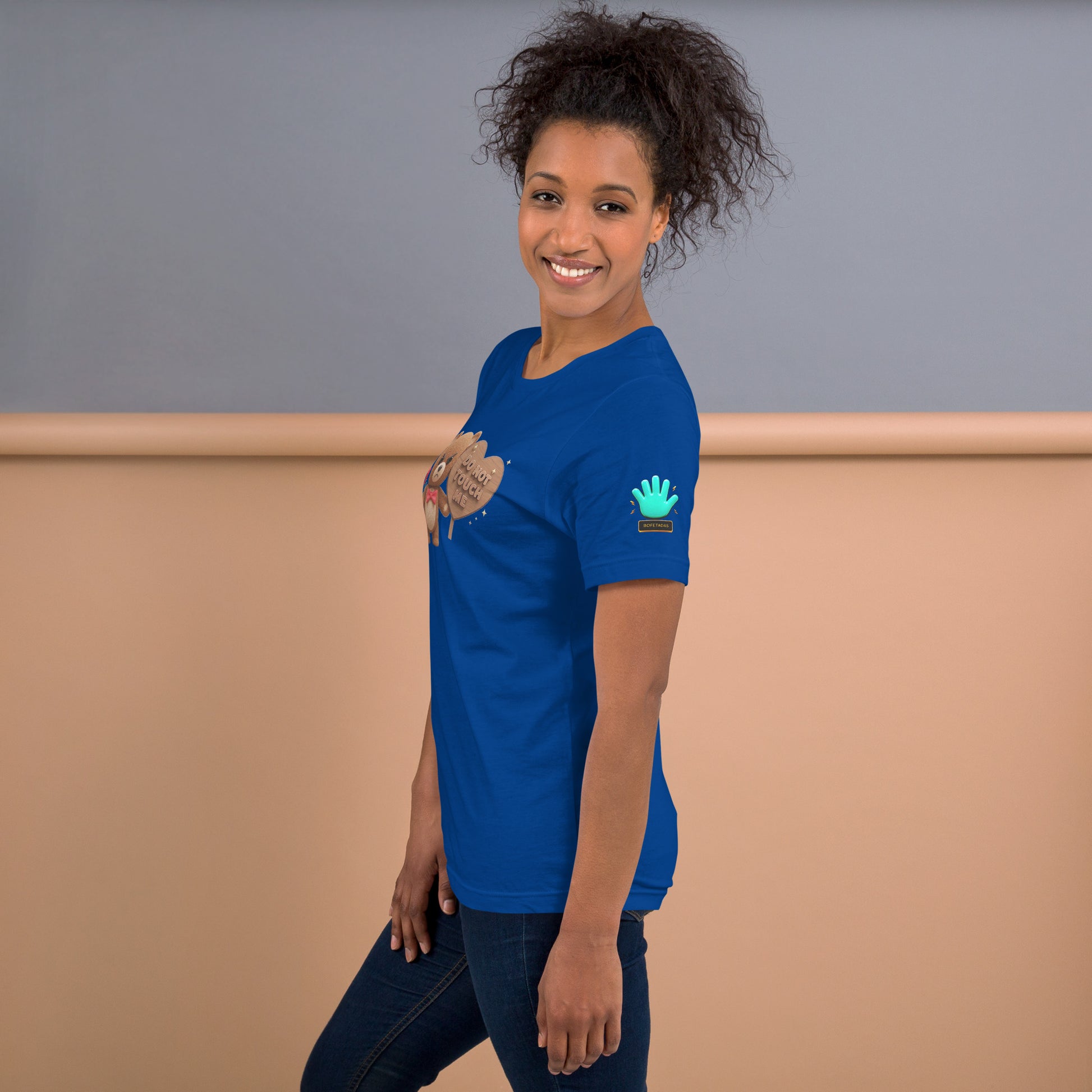 Modelo mostrando la vista lateral de camiseta azul de manga corta, marca Bofetadas, con el logotipo de una mano azul en la manga.