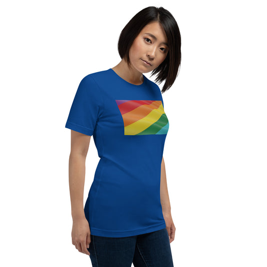 Modelo con jeans luciendo camiseta azul de manga corta marca Bofetadas, colección 'Causas Sociales', vista frontal, con bandera LGTBI+ rectangular ondeando.