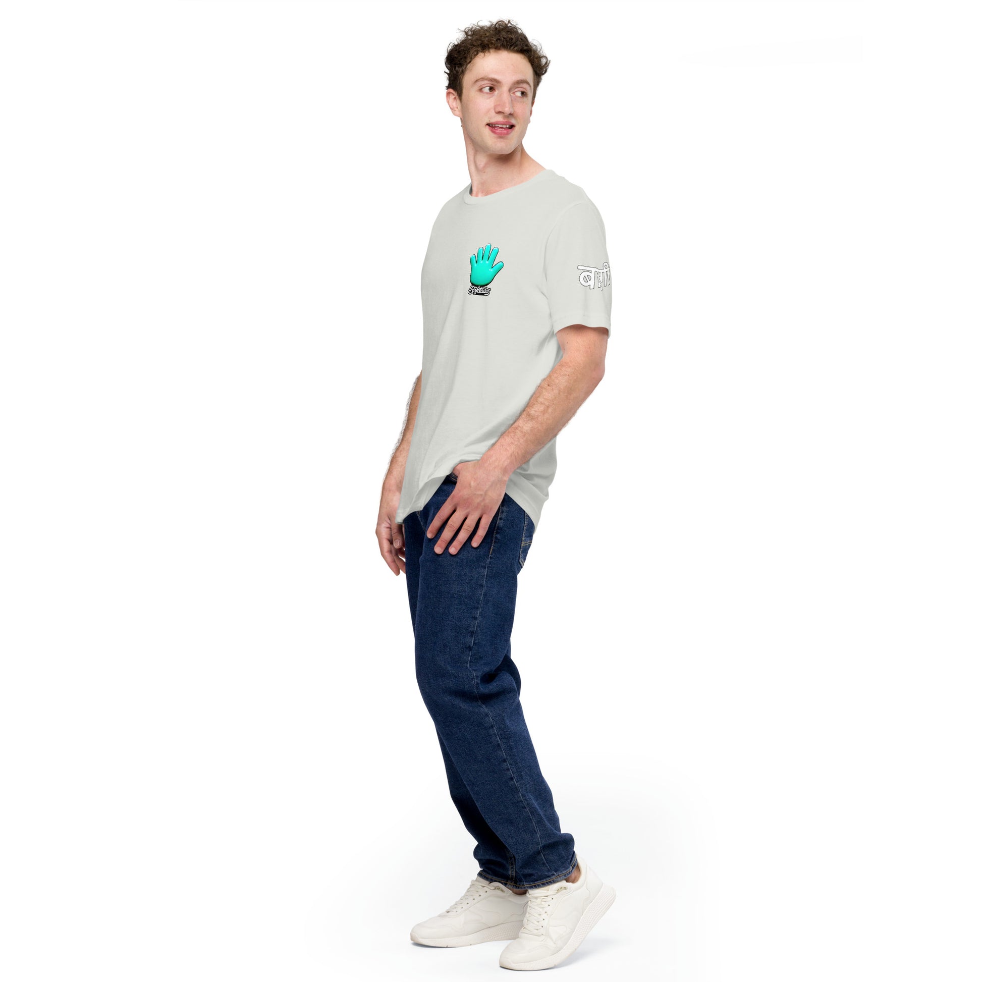 Un modelo con jeans mostrando la vista lateral ladeada de camiseta blanca de manga corta, marca Bofetadas, colección 'Causas Sociales', con el logotipo de una mano azul en el pecho y en la manga la palabra rebelde en indi con letras blancas bordeadas sutilmente en negro.