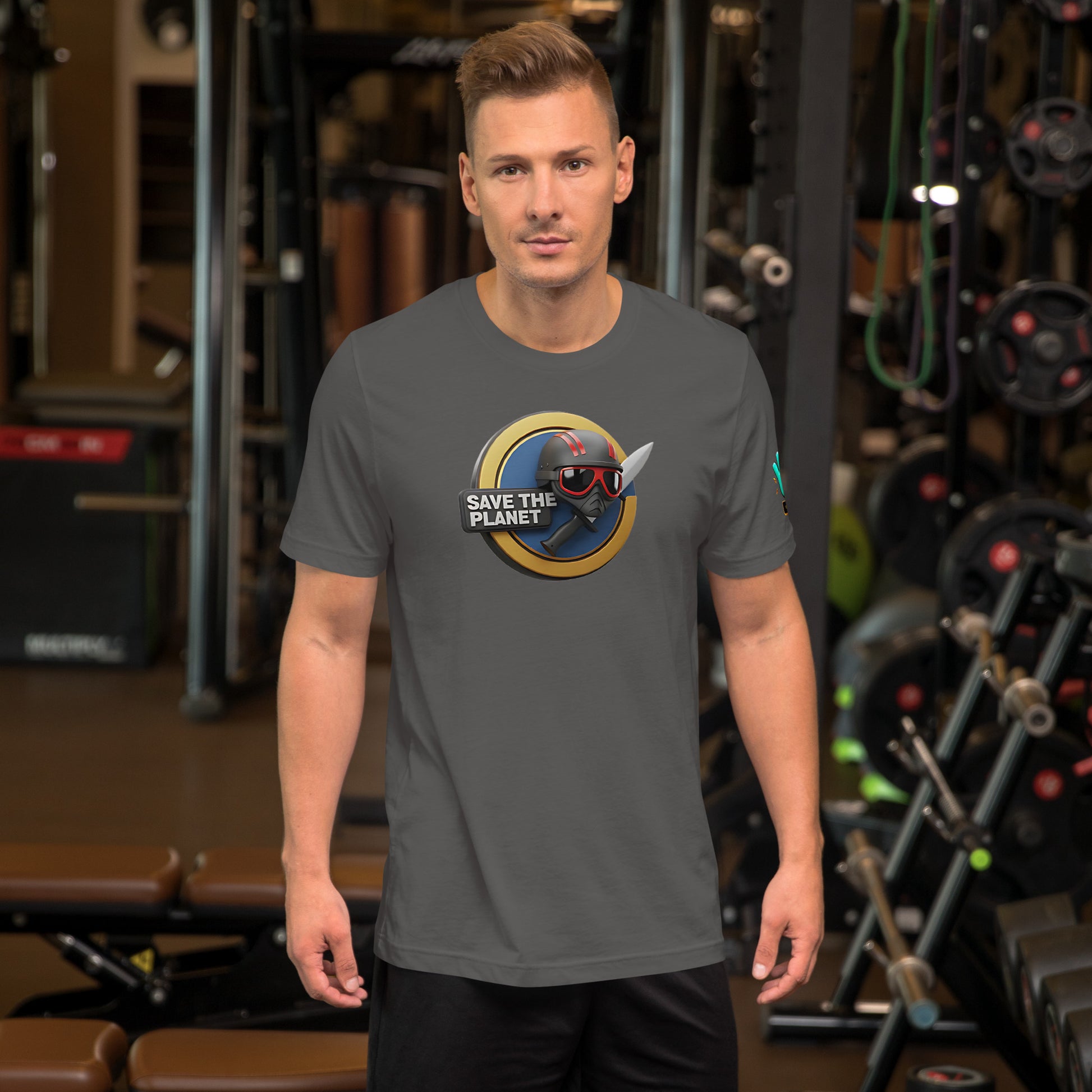 Modelo en gimnasio luciendo camiseta gris de manga corta marca Bofetadas, colección 'Causas Sociales', con escudo 'save the planet', casco y cuchillo.