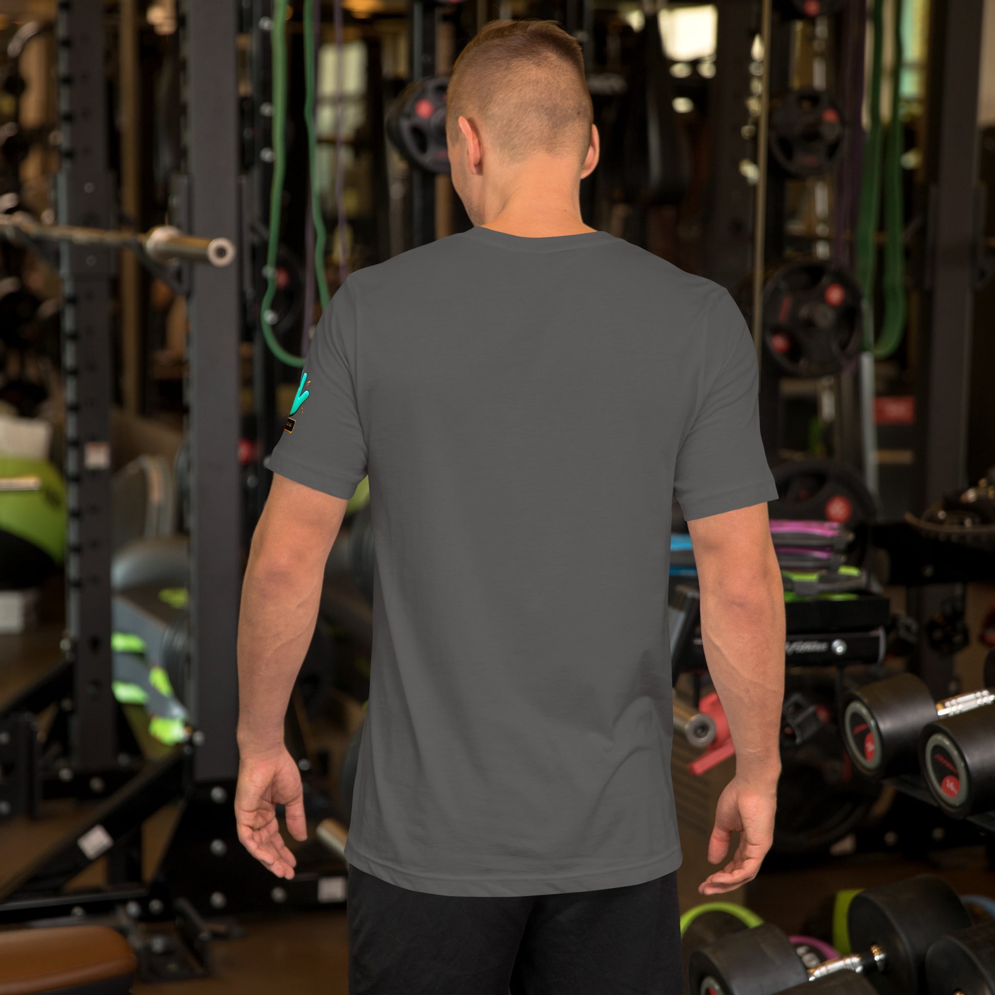 Modelo en gimnasio mostrando la vista trasera de camiseta gris de manga corta, marca Bofetadas, colección 'Causas Sociales', sin impresión