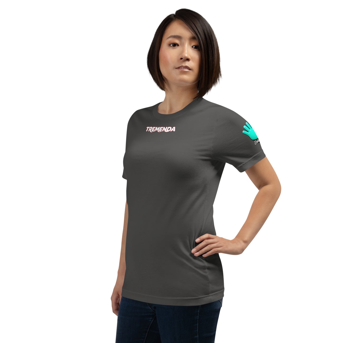 Una modelo con jeans luce una camiseta gris de Bofetadas colección 'Símbolos', vista frontal ladeada, con logo de la mano azul en la manga y el texto "TREMENDA" en el centro del pecho en la parte delantera.