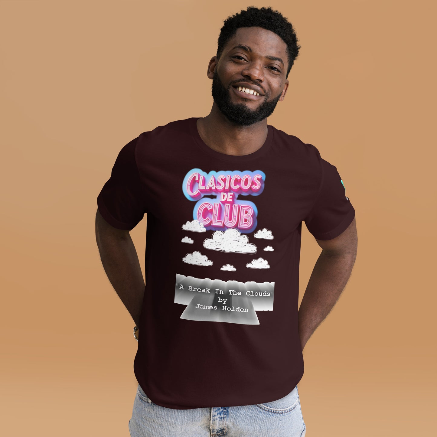 Camiseta marrón de manga corta de la colección Clásicos de Club de Bofetadas. La luce un modelo con jeans cortos. Diseño con el logotipo de la colección, unas nubes, el título y autor. Inspirada en el tema 'A Break in the Clouds' de James Holden.