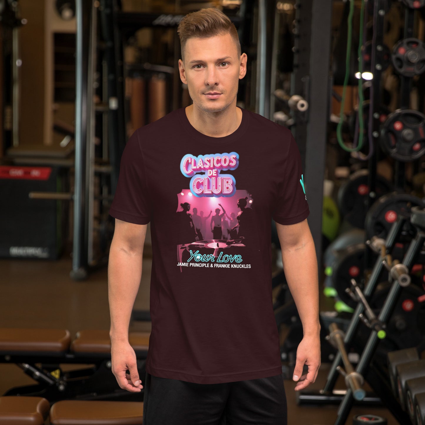 Modelo con vaqueros en gimnasio luciendo camiseta marrón de manga corta marca Bofetadas, colección 'Clásicos de Club', vista frontal, con texto 'Your Love by Frankie Knuckles & Jamie Principle', imagen oscura de una night club y logo neón rosa de Clásicos de club.
