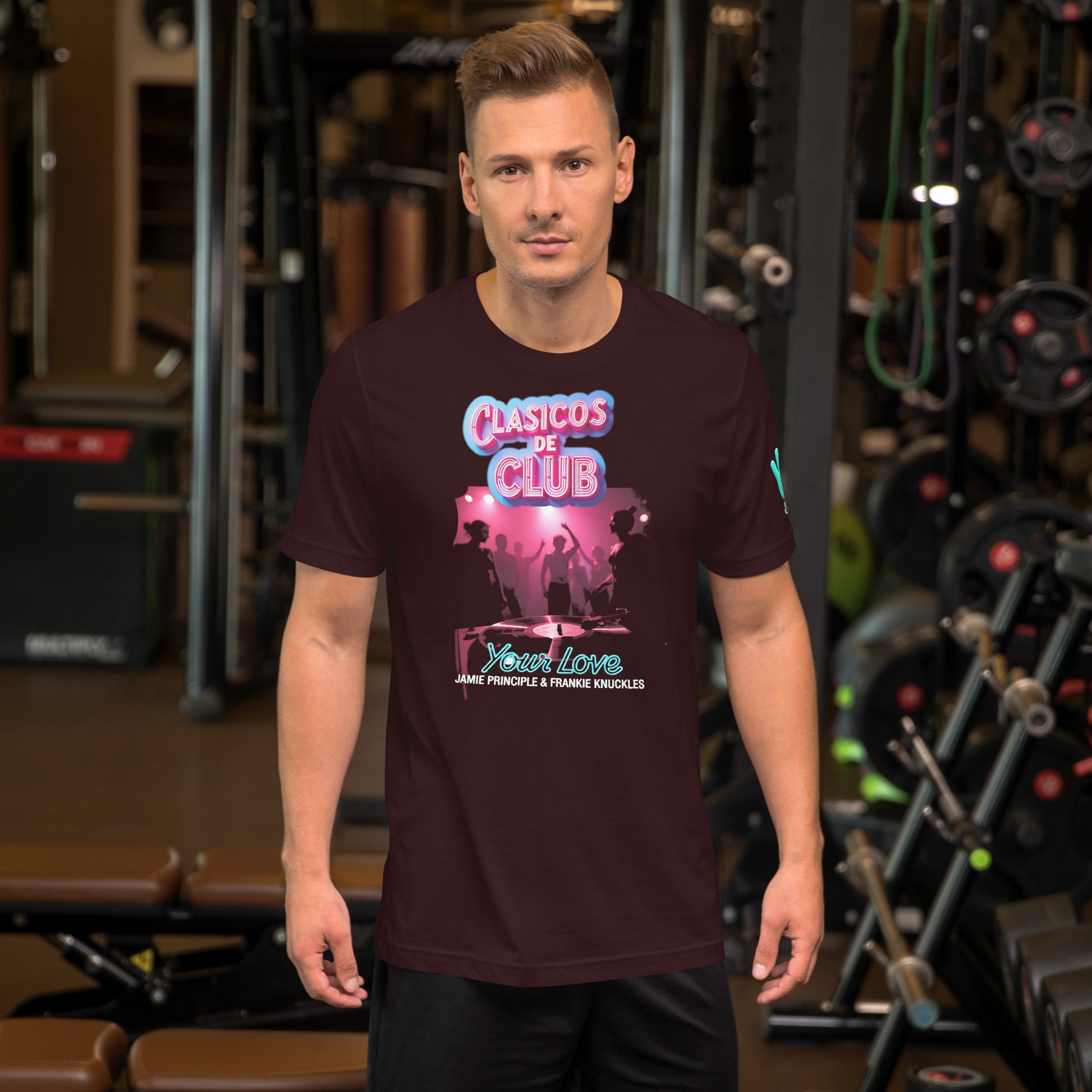 Modelo con vaqueros en gimnasio luciendo camiseta marrón de manga corta marca Bofetadas, colección 'Clásicos de Club', vista frontal, con texto 'Your Love by Frankie Knuckles & Jamie Principle', imagen oscura de una night club y logo neón rosa de Clásicos de club.