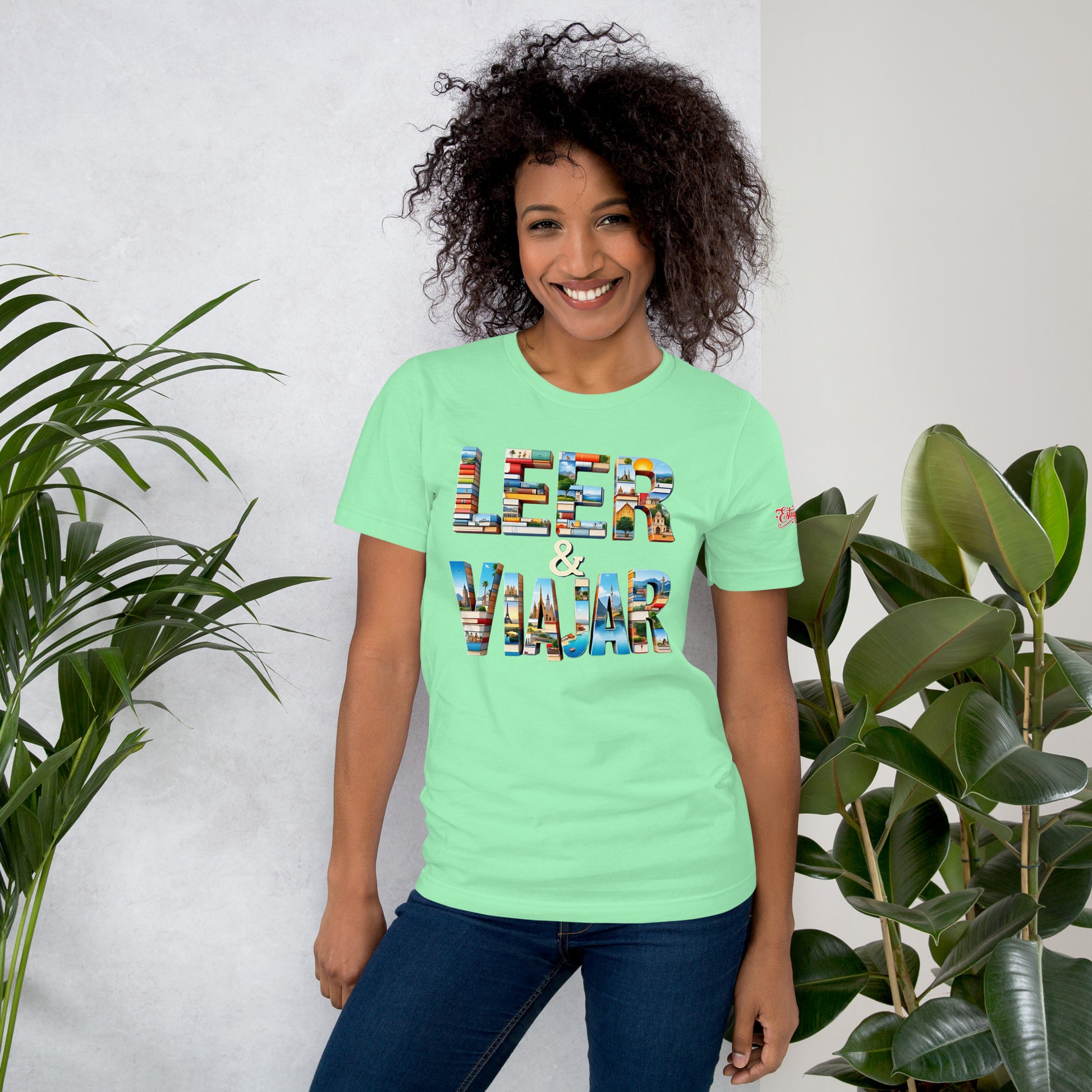 Una modelo sonriente en jeans luciendo camiseta ce color menta de manga corta marca Bofetadas, colección 'Frases y Mensajes', con texto 'leer & viajar' de fuente gruesa rellenada por libros y fotos de verano.