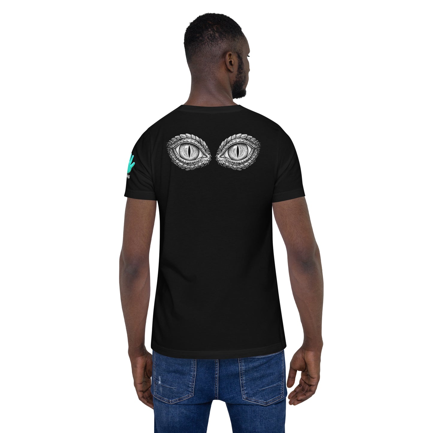Un modelo con barba y jeans luce la camiseta negra de bofetadas de la colección Mirada con la impresión en la espalda de los ojos de color blanco de un lagarto con la pupila vertical.
