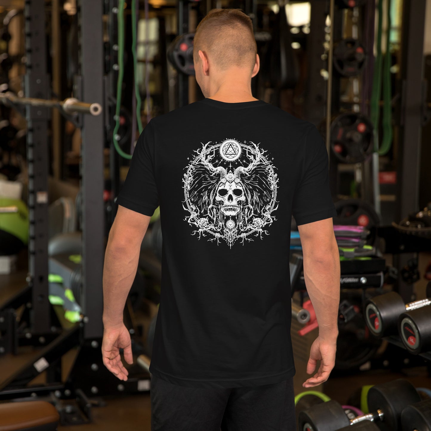 Un modelo de espaldas en un gimnasio luce camiseta negra de manga corta marca Bofetadas, colección 'Gótica', con impresionante calavera gótica en círculo intrincado.