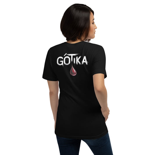 Modelo con jeans luce camiseta negra colección 'Gótica', vista trasera, con texto 'GOTIKA' en letras blancas desgarradas y gran gota de sangre cayendo.