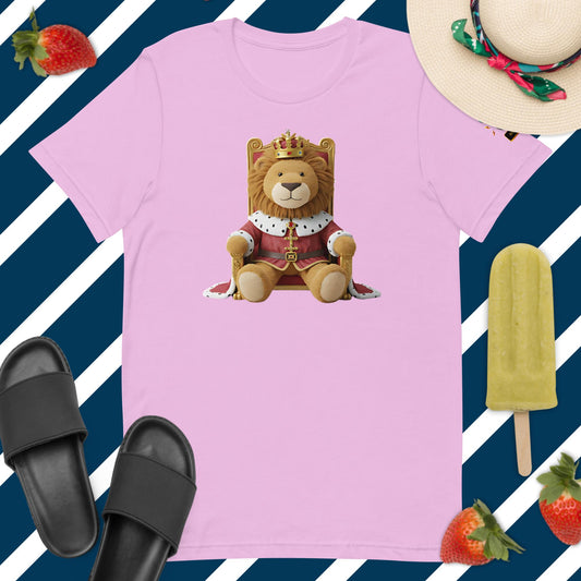 Camiseta rosa de manga corta marca Bofetadas, colección 'Animales', con león de peluche con ropa y capa de rey, corona y sentado en trono.