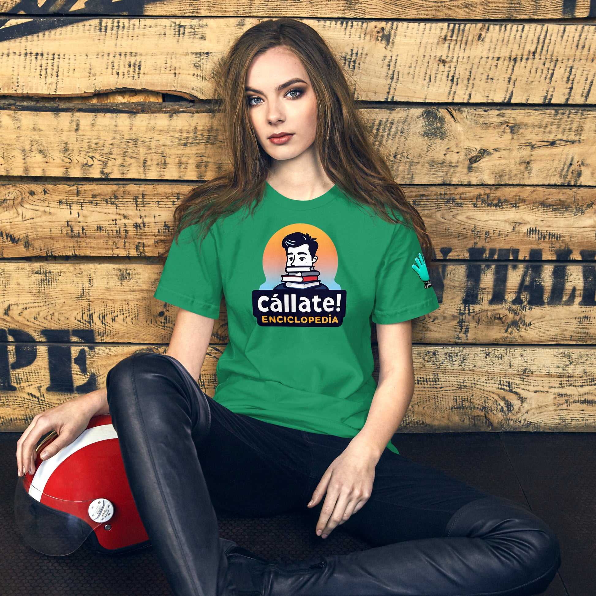 Una modelo sentada en su habitación luce una camiseta verde de manga corta marca Bofetadas, colección 'Frases y Mensajes', con ilustración de empollón y libros junto al texto 'cállate enciclopedia'.