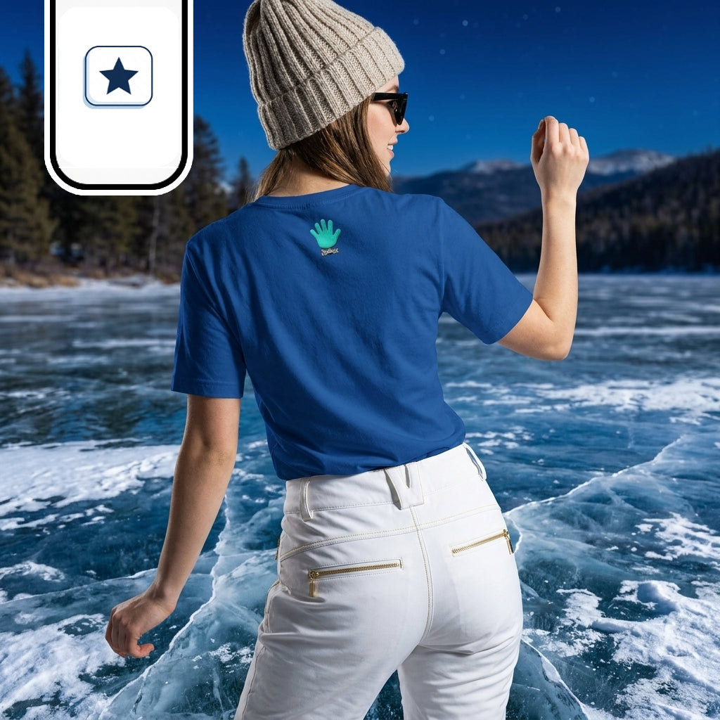 Una joven posa de espaldas sobre la superficie congelada y agrietada de un lago invernal.
Lleva un gorro de lana beige, gafas de sol, pantalón de esquí blanco y una camiseta azul royal con el logo de una mano turquesa en la espalda.
El paisaje combina agua helada con reflejos celestes y un fondo de montañas y abetos bajo el cielo nocturno.