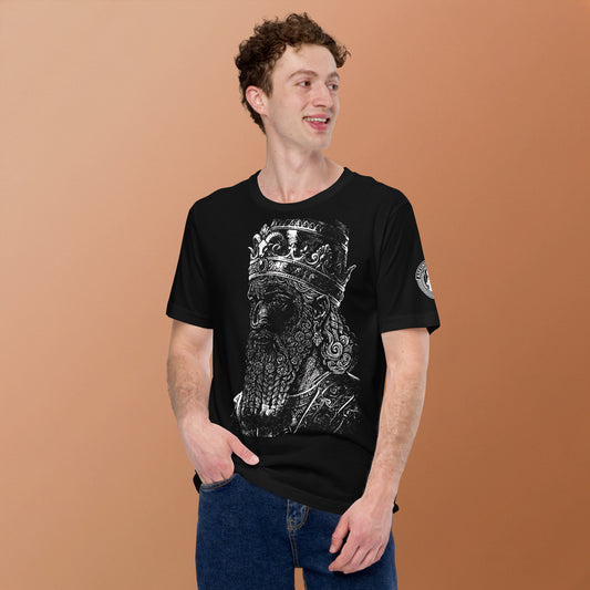 Un modelo sonriente muestra la cara de esta camiseta negra de Bofetadas de la colección asesinos en serio con la impresión de la ilustración en tinta blanca de un rostro que pretende ser Nabucodonosor II.