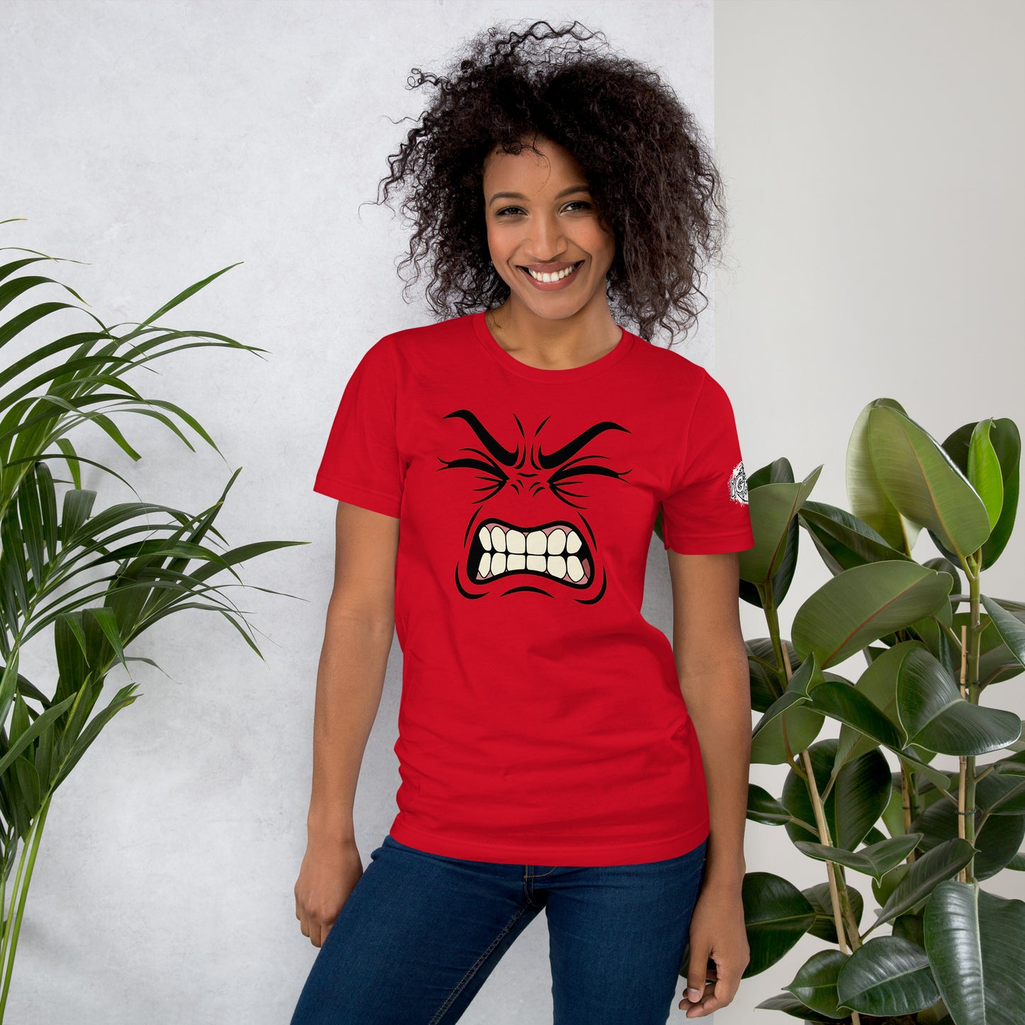 Una modelo sonriente con jeans luce una camiseta de Bofetadas de la colección Emo llamada Furia. Vista delantera con la impresión de una expresión minimalista  que concentra toda la intensidad del momento. Unas **cejas fruncidas**, unos **ojos tensos** y una **boca desencajada**.