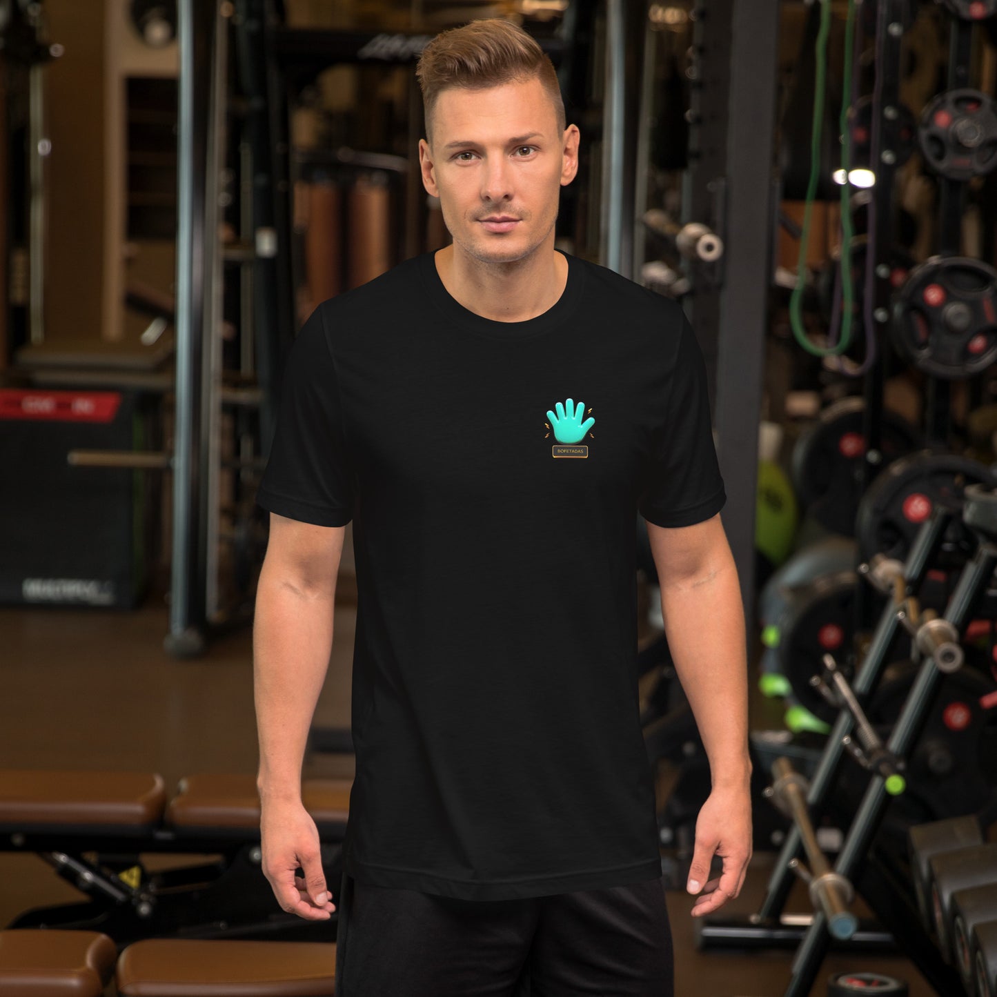 Un modelo en un gimnasio luce una camiseta negra de manga corta marca Bofetadas, colección 'Gótica', con el logo de la mano azul en el pecho.